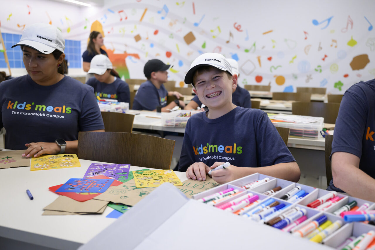 Child volunteer at Kids' Meals decorating bags